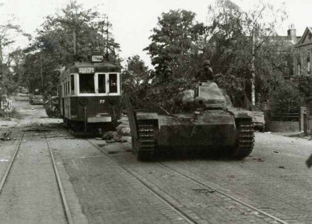 Sturmgeschütz StuG III Ausf. G egy súlyosan sérült villamos előtt, Utrechtsewegben, a Market Garden alatt, 1944. szeptember 19-én. Egy elesett katona fekszik a villamos előtt.